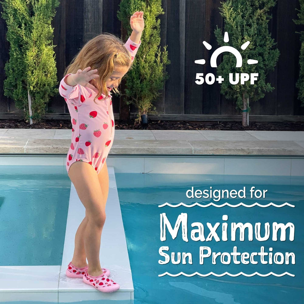 JAN & JUL Girls One Piece UV Swimsuit Pink Strawberry, girl balances on pool edge to show 50+ UPF protection.