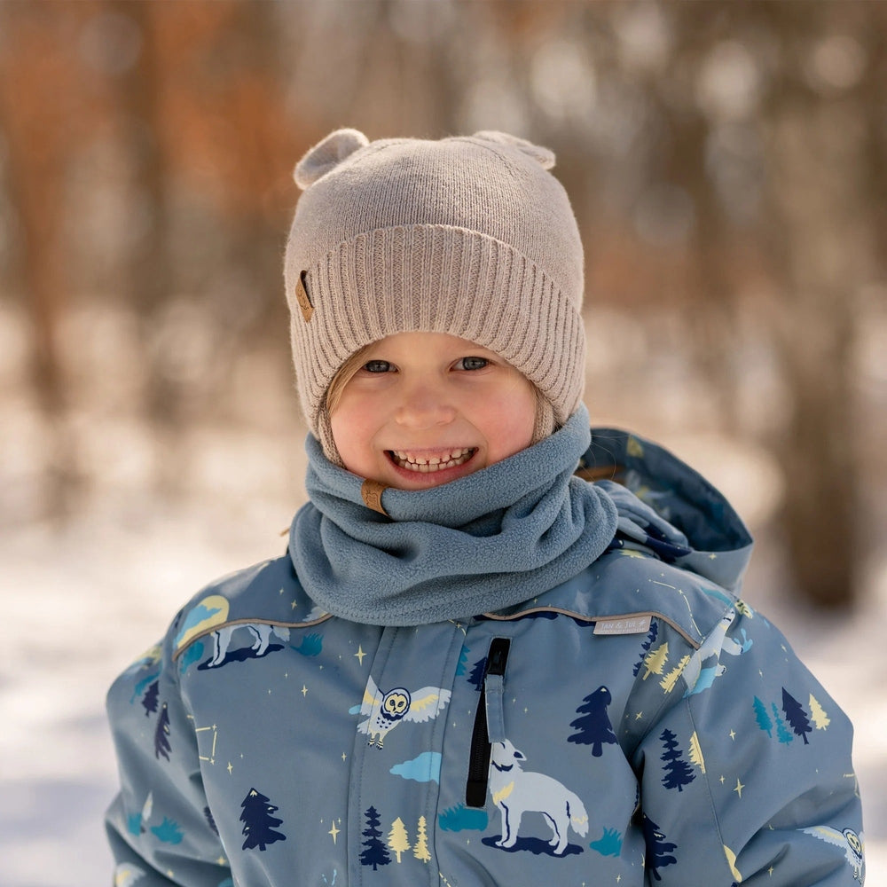 JAN & JUL Kids Bear Knit Hat in wheat field beige; cozy knit with bear ears, worn by smiling child.