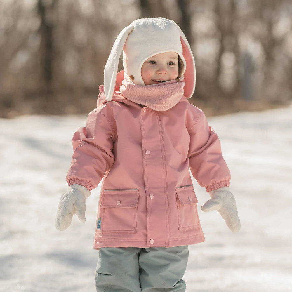 Jan & Jul Kids Fleece Animal Cream Bunny hat with long ears worn by a child in a pink coat outdoors.