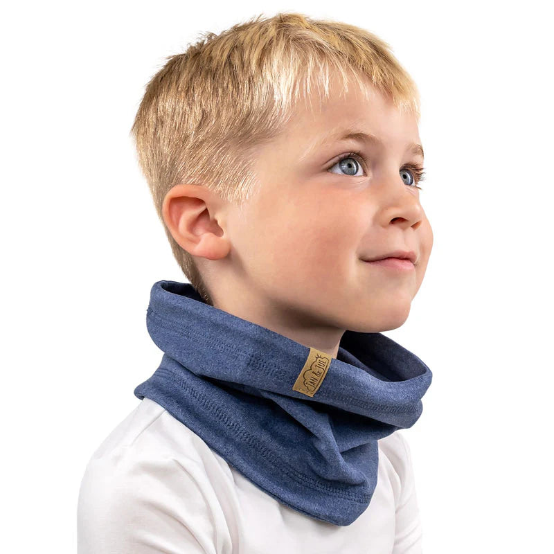 JAN & JUL Kids Fleece Neck Warmer in blue worn snugly around a smiling boy, with brand tag visible.