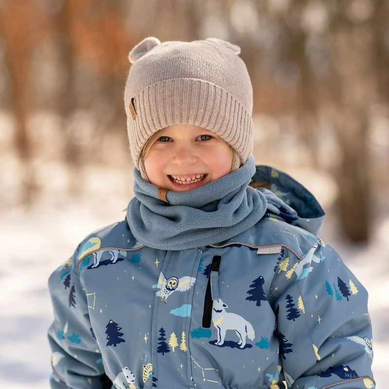 JAN & JUL fleece neck warmer in stormy blue worn by a smiling child in a winter outdoor setting