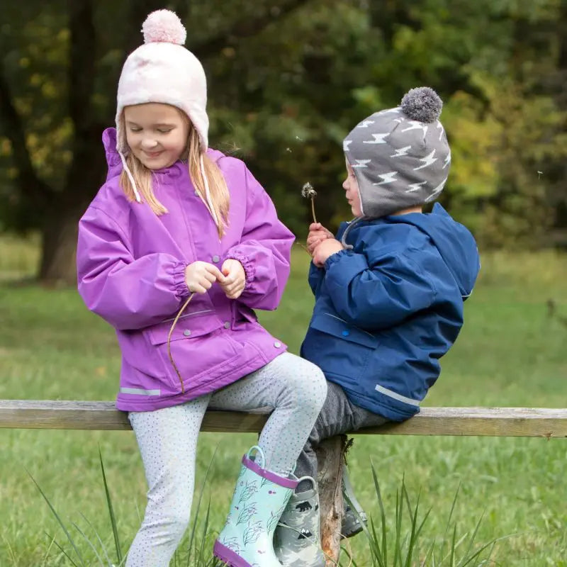 Jan & Jul Kids Knitted Beanies Hat Grey Lighting Bolt worn by a boy and a girl on a park bench in autumn light.