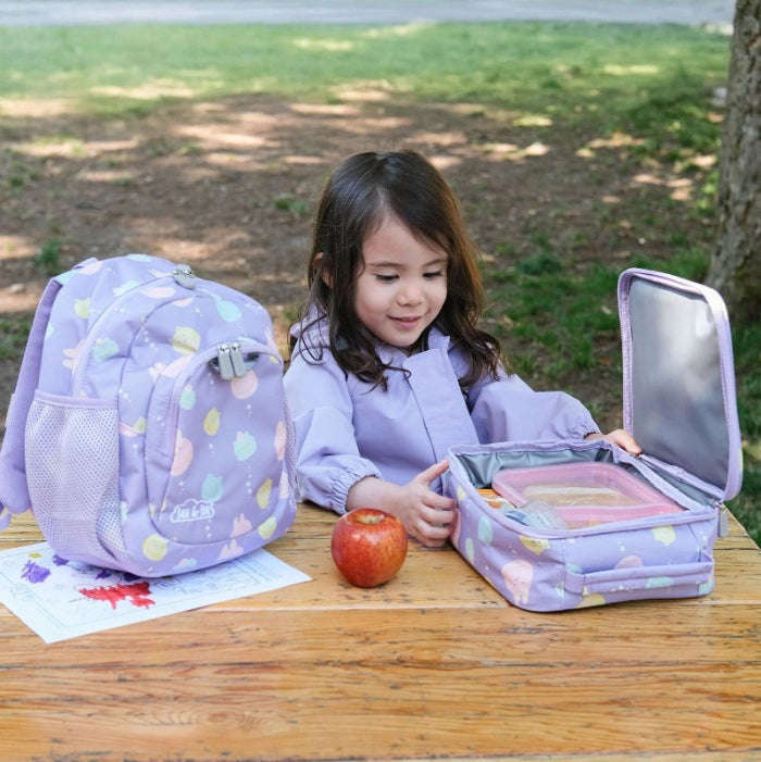 Jan & Jul macarons lunch bag with matching lavender backpack, 2-piece set, open lunch box visible.