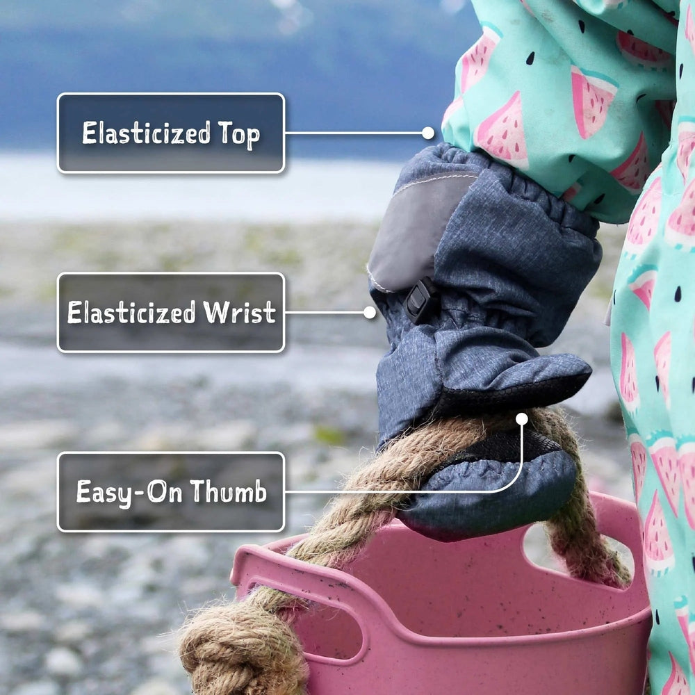 JAN & JUL Kids Rain Mittens Lavender with elasticized top and wrist, easy-on thumb, worn by a child near a rainy beach.