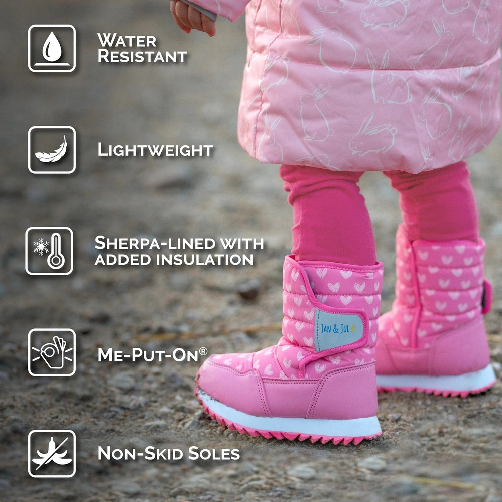 JAN & JUL Kids Tall Puffy Winter Boots dusty pink with hearts; sherpa-lined insulation and non-slip soles as a toddler walks.