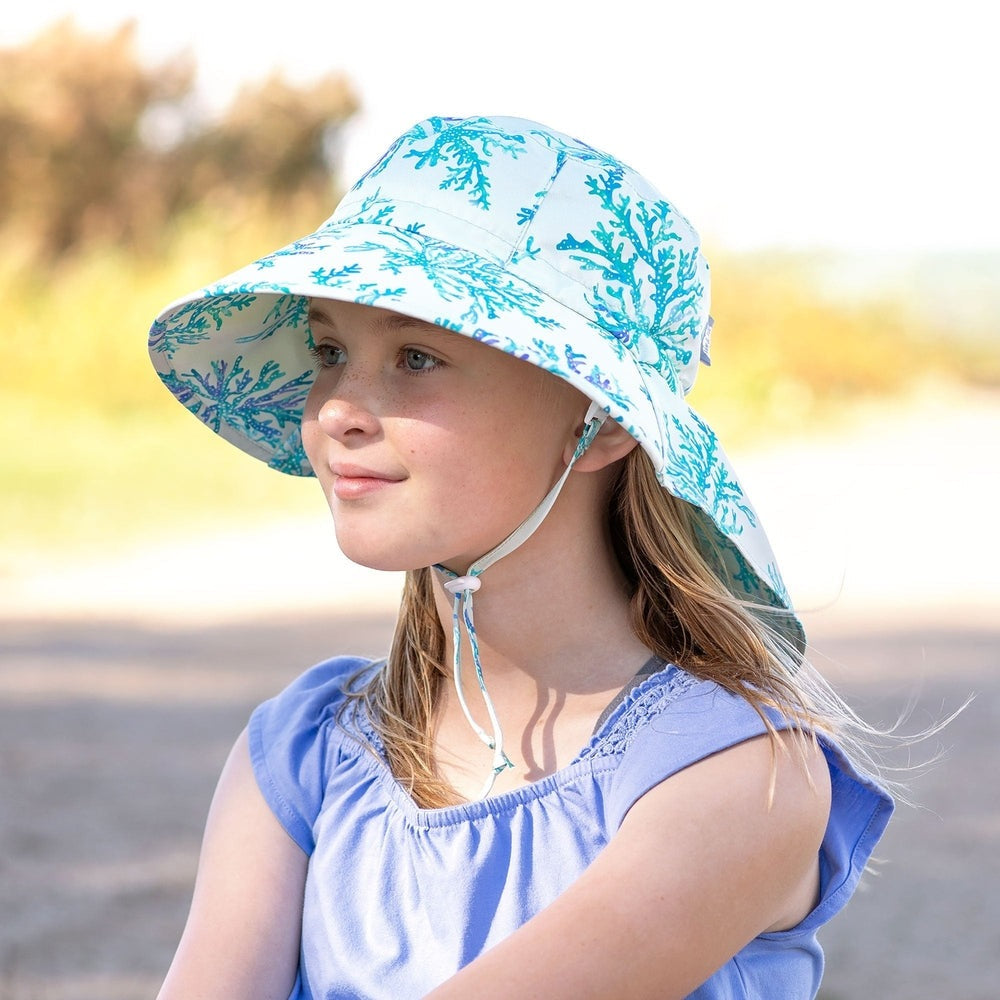 Jan & Jul Kids Water Repellent Adventure Hat Blue Coral print worn by a girl outdoors with a secured chin strap.