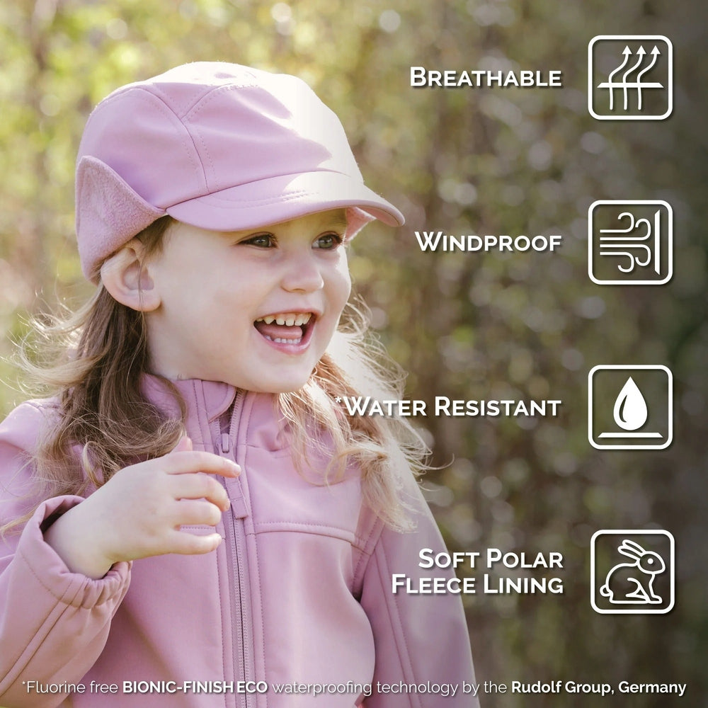 Jan & Jul Kids Water Resistant Softshell Cap Dusty Rose worn by a smiling toddler outdoors, showcasing windproof and water resistance.