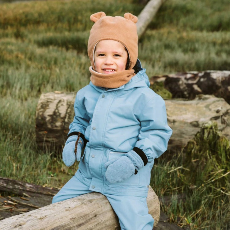 Jan & Jul Waterproof Cozy Dry Rain Jacket Dusty Blue worn by a child sitting on a log outdoors.