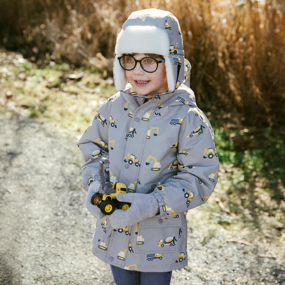 JAN & JUL grey waterproof rain jacket with construction vehicle print and fur-lined hood worn by a child