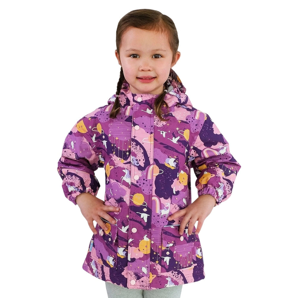 JAN & JUL Waterproof Cozy Dry Rain Jacket Purple Dream worn by a smiling girl with hood up and hands in front pockets.