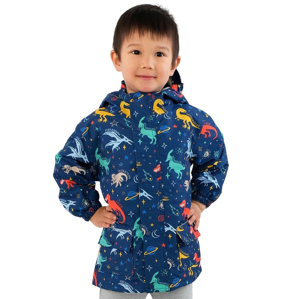 JAN & JUL Waterproof Cozy Dry Rain Jacket Space Dinos in blue with hood, worn by a child standing with hands on hips.