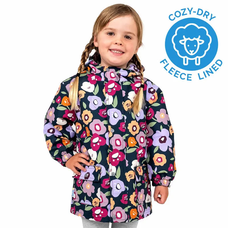 JAN & JUL Waterproof Cozy Dry Rain Jacket Winter Flowers in navy floral print, fleece-lined, worn by smiling girl.