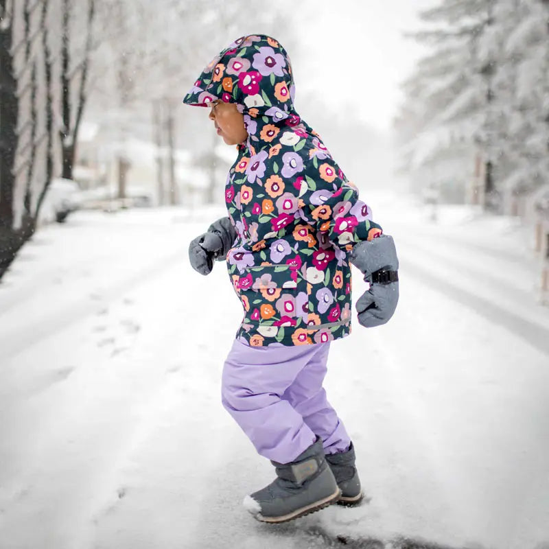 JAN & JUL Waterproof Cozy Dry Rain Pants Lavender for kids, worn by a child walking in the snow.