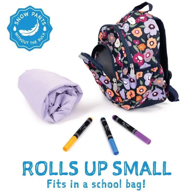 Jan & Jul Waterproof Cozy Dry Rain Pants Unicorn, rolled lavender pants beside a floral backpack and markers.