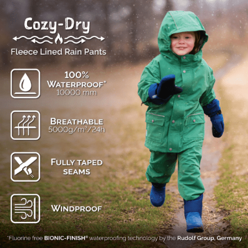 JAN & JUL Waterproof Cozy Dry Rain Pants, green fleece-lined, worn by a child in the rain to show fully taped seams