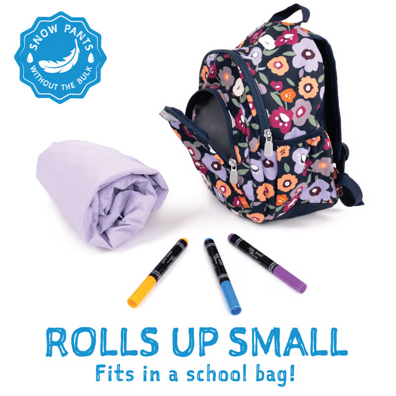 Jan & Jul Waterproof Cozy Dry Rain Pants Yellow rolled up beside a floral backpack, showing compact roll-up design.