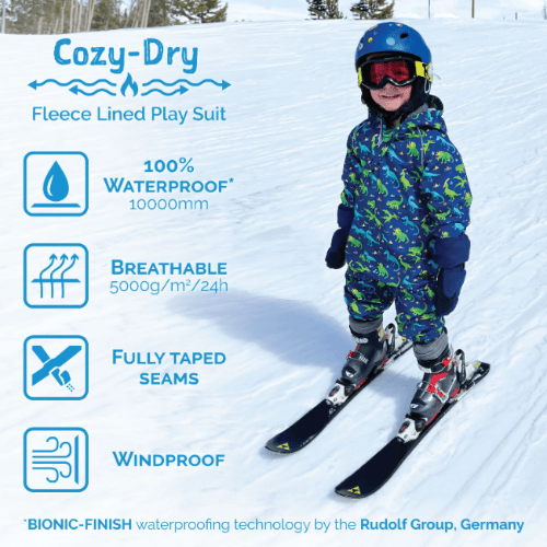 JAN & JUL Cozy Dry rain suit; blue dinosaur-print fleece-lined outerwear with taped seams, worn by a child on snow.