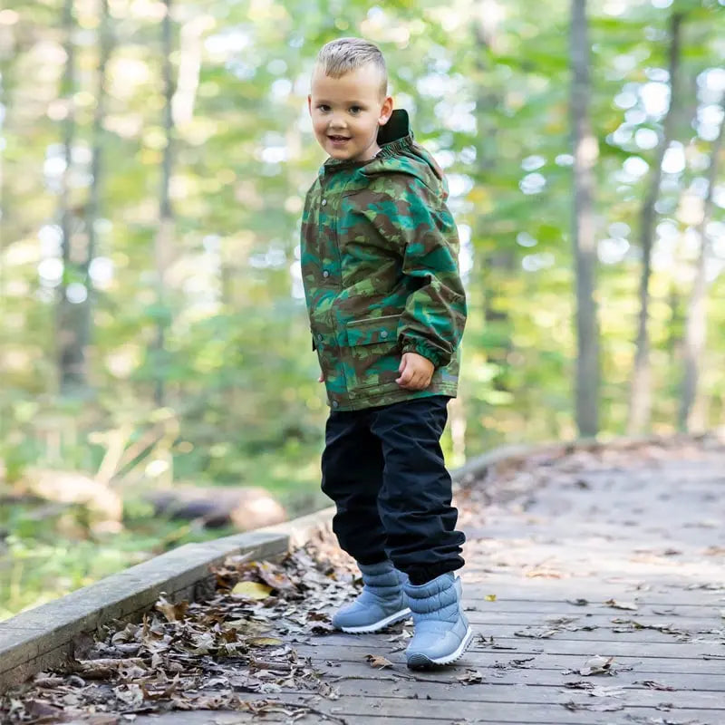 Jan & Jul Waterproof Puddle Dry Rain Pants Black worn by a toddler on a forest path during outdoor play.