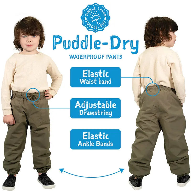Two kids wear Jan & Jul Dreamscape waterproof rain pants in khaki, showing elastic waist with drawstring and elastic ankle bands.
