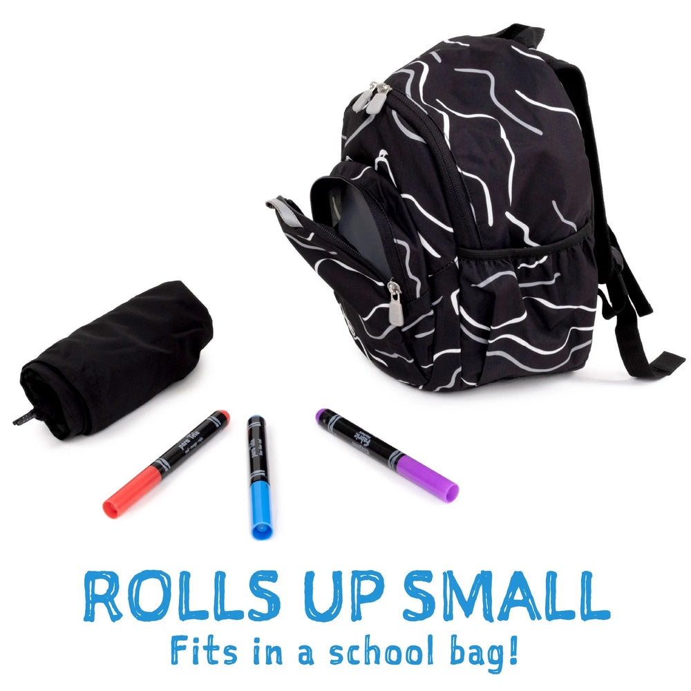 Jan & Jul Waterproof Puddle Dry Rain Pants Greystone, rolled up compactly beside a backpack to show bag-ready storage.