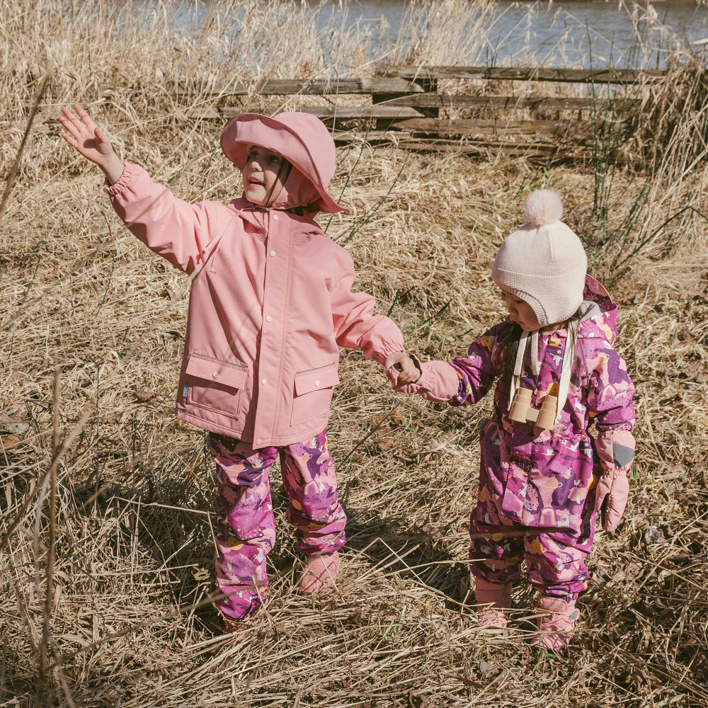 Jan & Jul Purple Dream waterproof rain pants for kids; two children in pink and purple outfits outdoors.