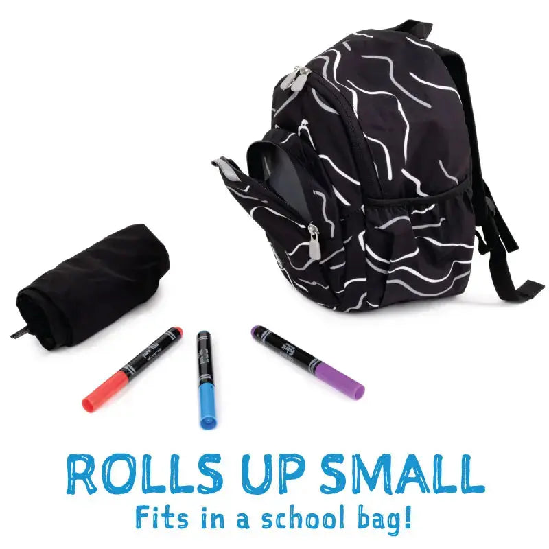 JAN & JUL Unicorn waterproof puddle-dry rain pants compactly rolled in a black pouch beside a school backpack.