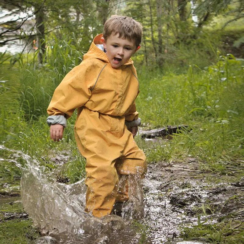 Jan & Jul Waterproof Puddle Dry Rain Suit Yellow; toddler splashes through a muddy puddle in a bright rain suit.