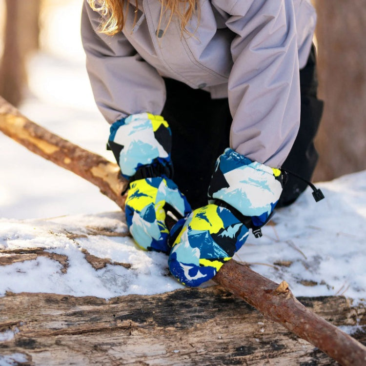 Jan & Jul Waterproof Toasty Dry Mitten Neon Peaks in blue/teal/yellow, toddler gripping a snowy log.