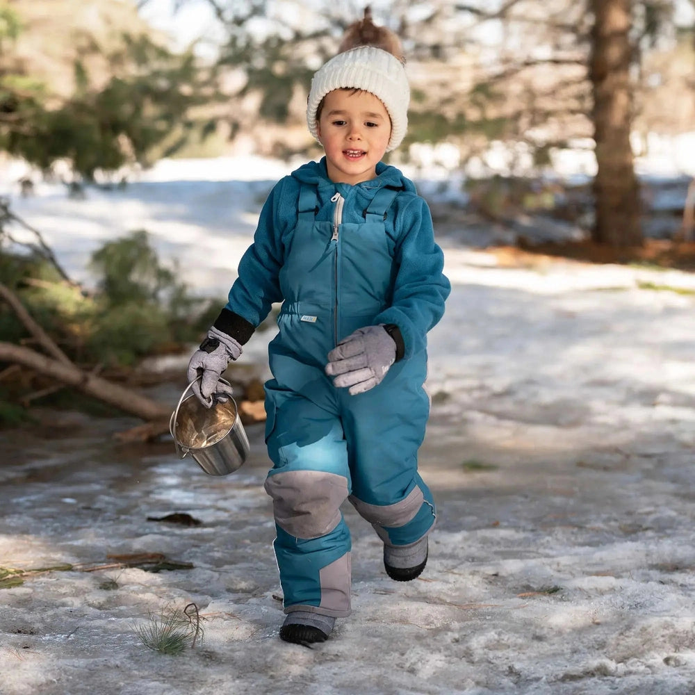 Toddler wearing Jan & Jul Waterproof Toasty Dry Snow Gloves Mint Star in teal, gray palms, holding a metal bucket.