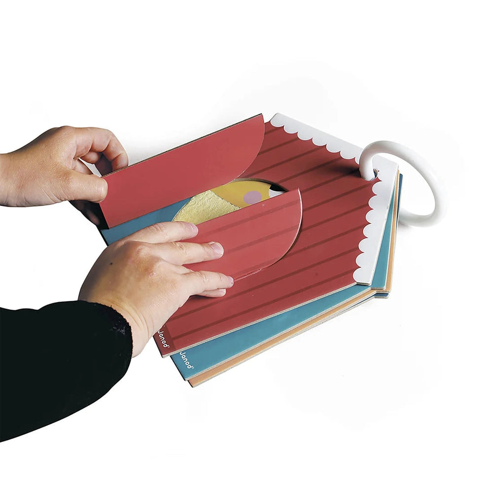 JANOD Tactile Cards Set, red striped card opened by hands to reveal textures for tactile learning.