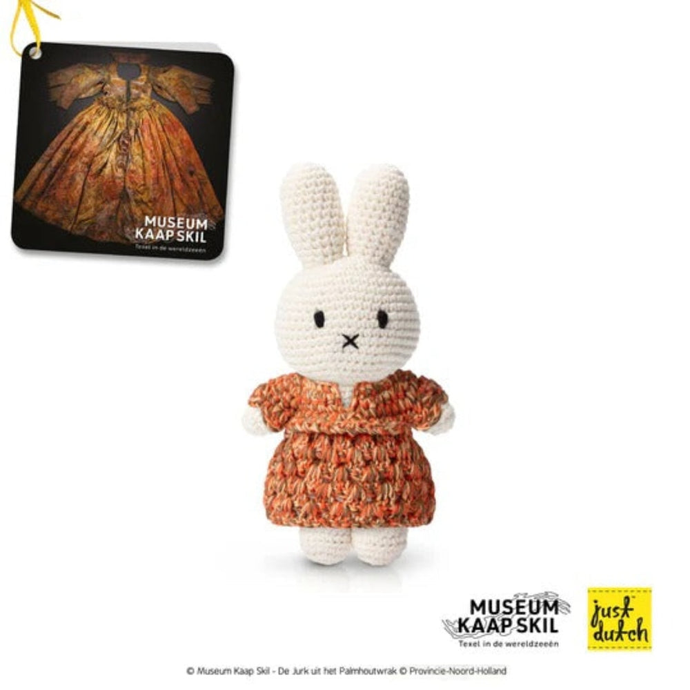 Just Dutch Miffy Handmade And Her Kaap Skill Dress crochet bunny plush stands upright in an orange dress.