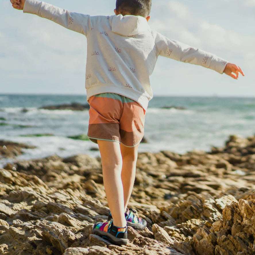 KEEN Little Kids Newport H2 Sandal with multicolor straps worn by child on rocky beach