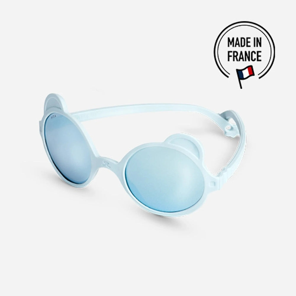 Ki Et La Ourson sunglasses in sky blue round frames with bear-ear sides worn by a toddler.