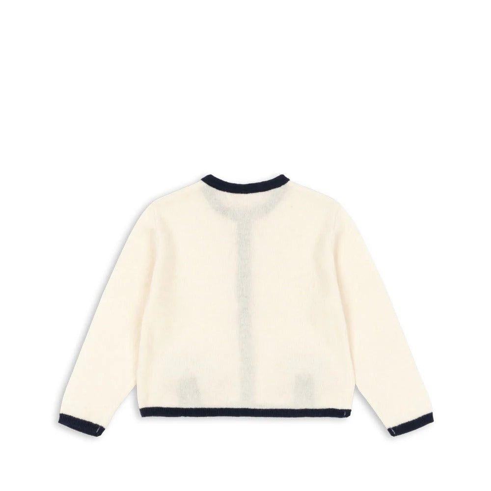 Konges Slojd Alette Cardigan Etoile in cream with navy trim, laid flat to show soft knit and navy cuffs.
