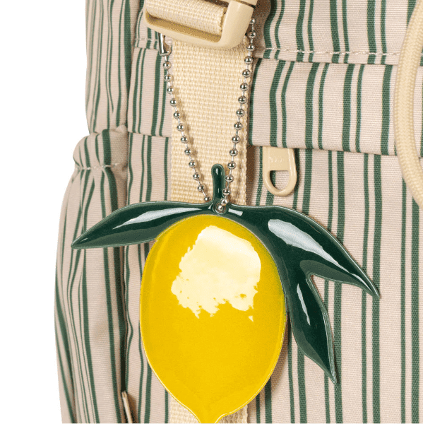 Konges Slojd Clover schoolbag with a yellow fruit charm on a beige-green striped backpack