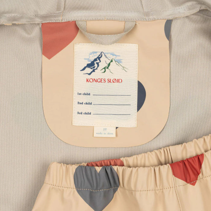 Konges Slojd Faire Rain Set: beige baby rain coat with pastel heart prints and matching pants