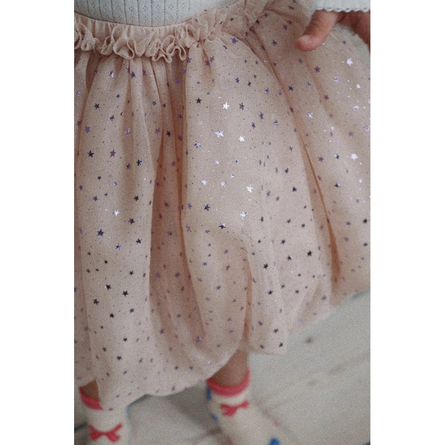Konges Slojd Fairy Balloon Skirt Fairy Etoile, peach tulle with glitter stars, twirled to reveal its fluffy volume.