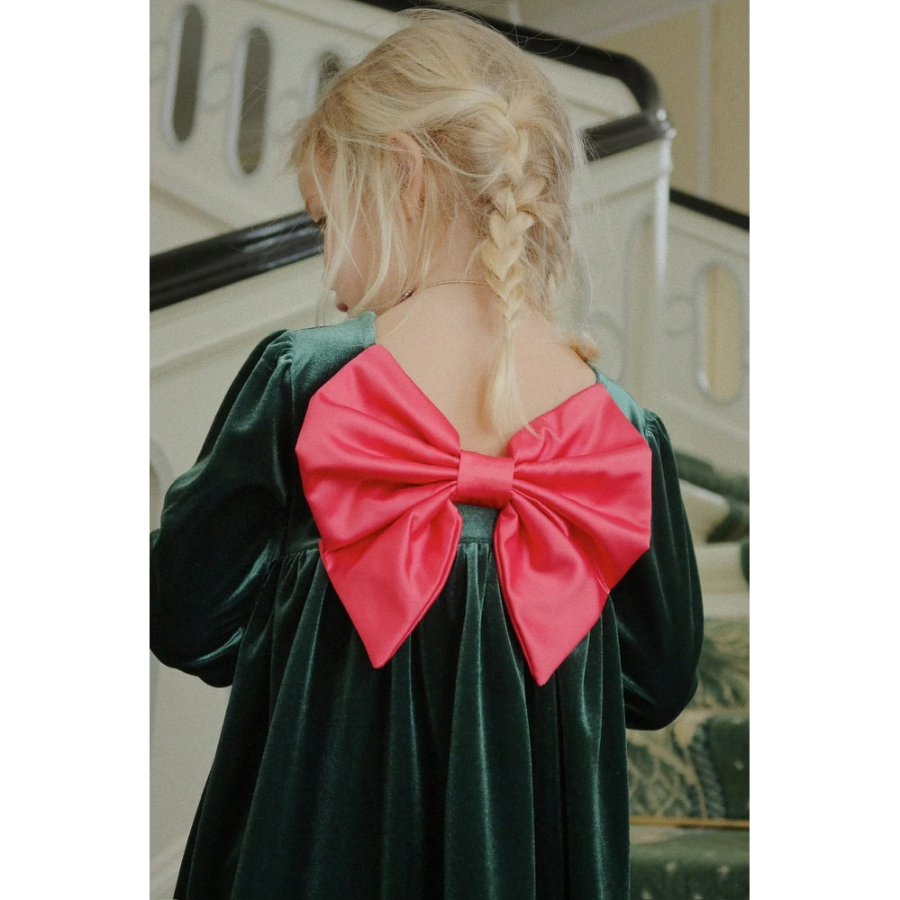 Konges Slojd Gia Bow Dress Pine Grove: green velvet toddler dress with a large pink bow on the back.