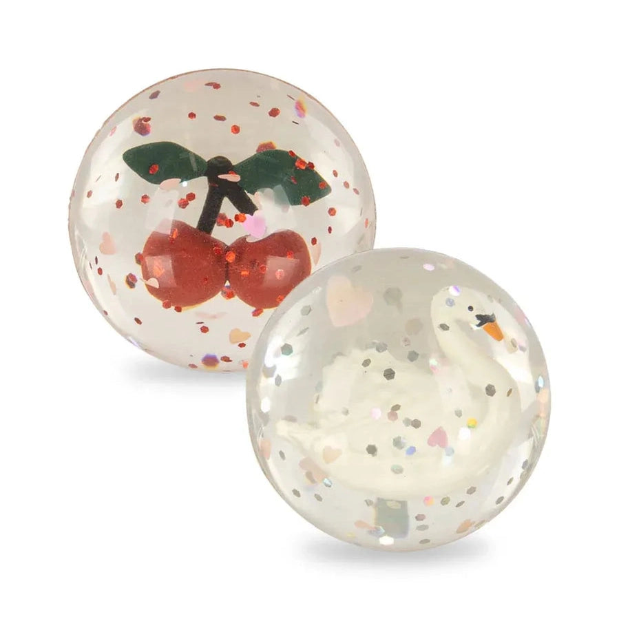 Konges Slojd Glitter Bouncing Ball Set Cherry/Swan, two clear glitter balls featuring a cherry and a swan motif.