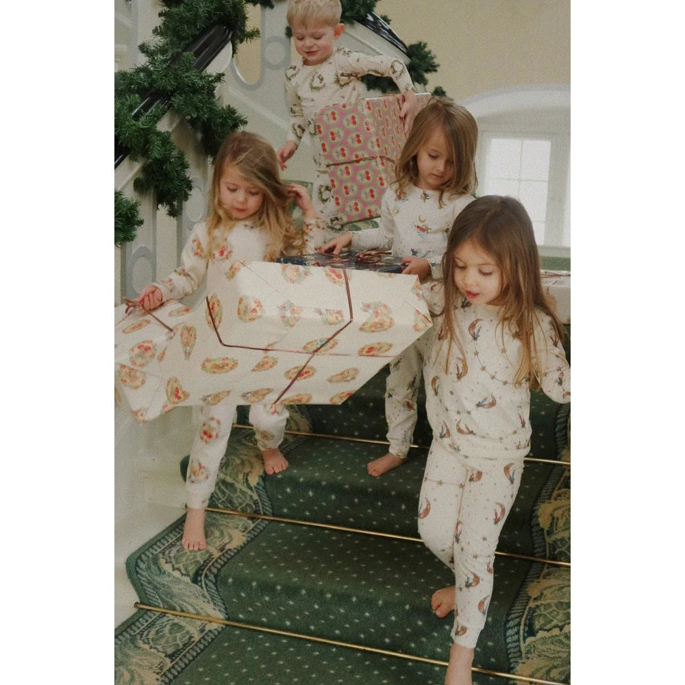 Konges Slojd Holiday Basic Blouse/Pants Set GOTS Deer Diary worn by kids carrying wrapped presents down a staircase.