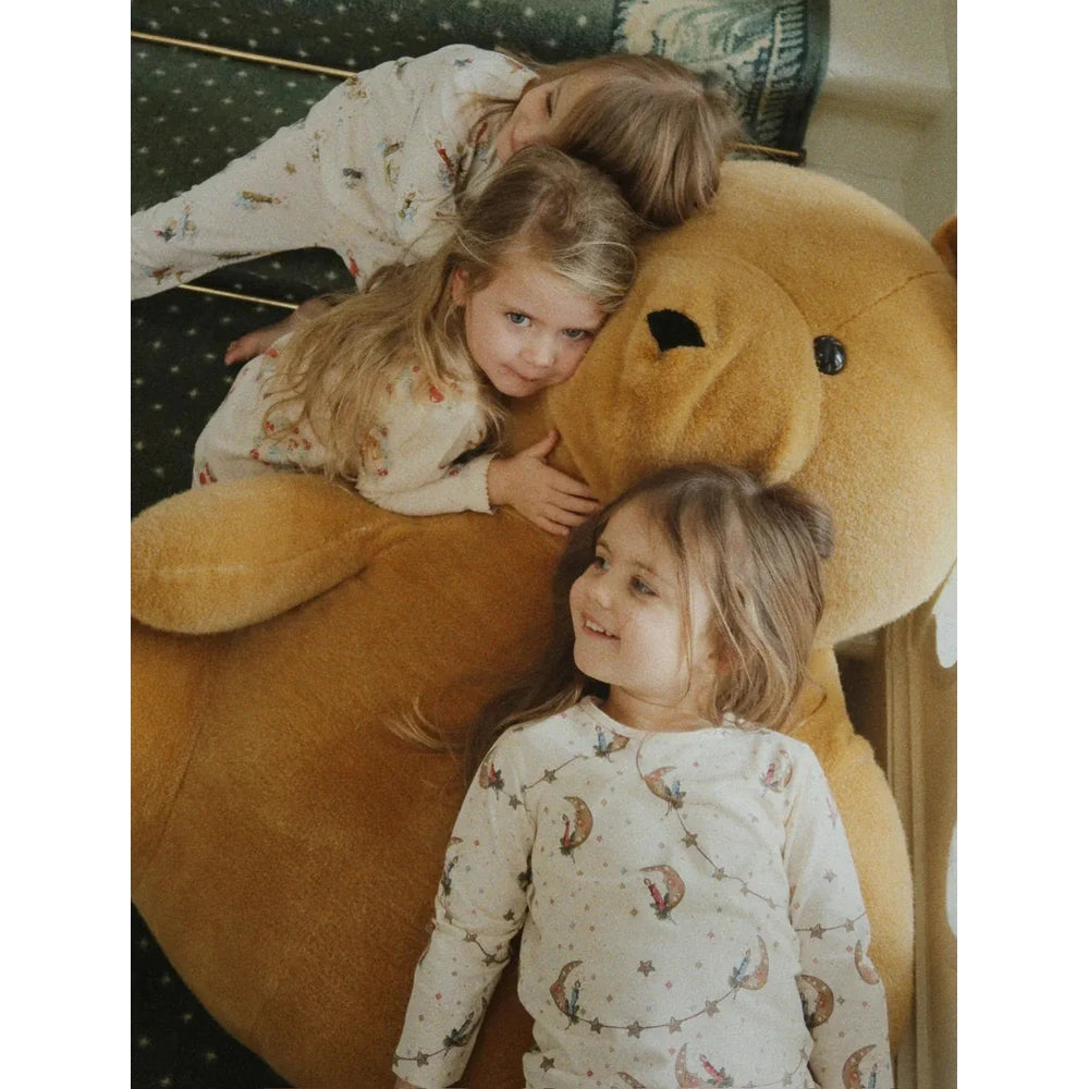 Konges Slojd Holiday Basic Blouse/Pants Set Gots Luna cream moon-star print worn by kids cuddling a giant teddy bear.