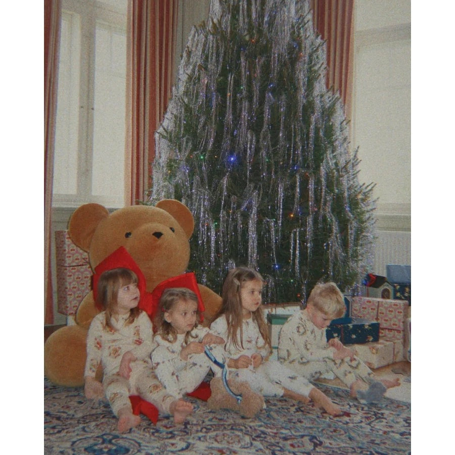 Konges Slojd Holiday Basic Blouse/Pants Set Gots Luna worn by four toddlers in white patterned sleepwear sit by a Christmas tree with gifts