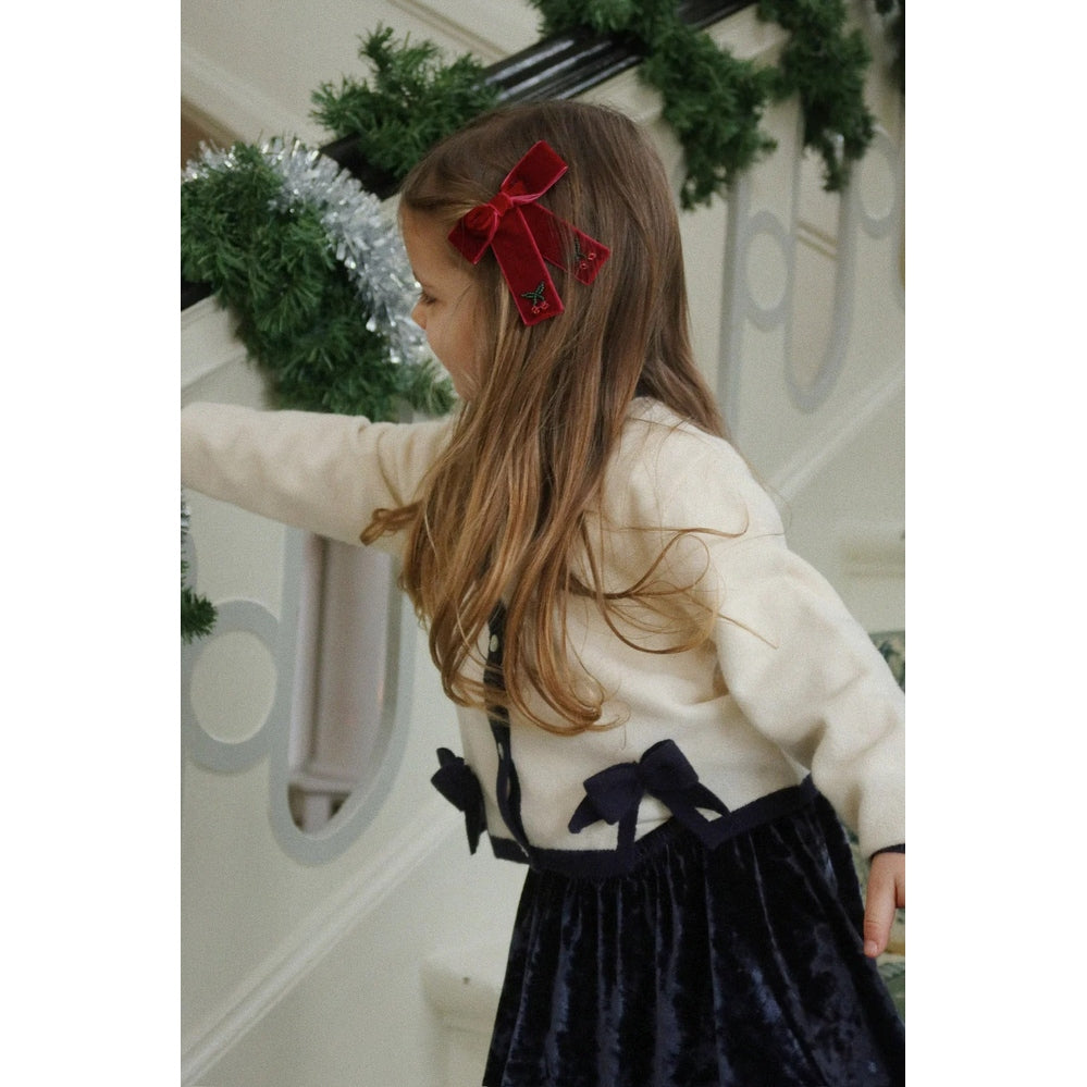 Konges Slojd Juliette Bow Hair Clip 2 Pack Rio Red on a girl with a red velvet bow in a festive setting.