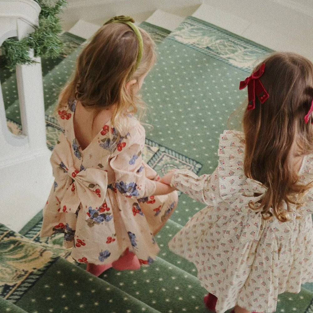 Konges Slojd Juliette Bow Hair Clip 2 Pack Rio Red: two girls on a green stair carpet show off red hair bows.