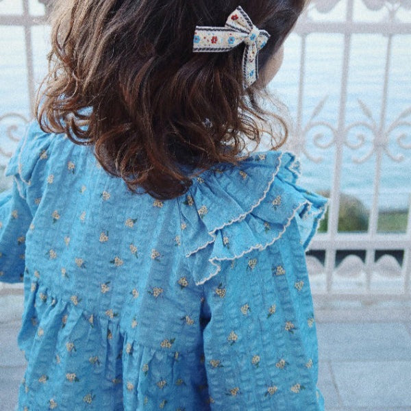 Konges Slojd Kim Frill Blouse Billie Blue worn by a toddler, blue print fabric with a layered ruffle collar.