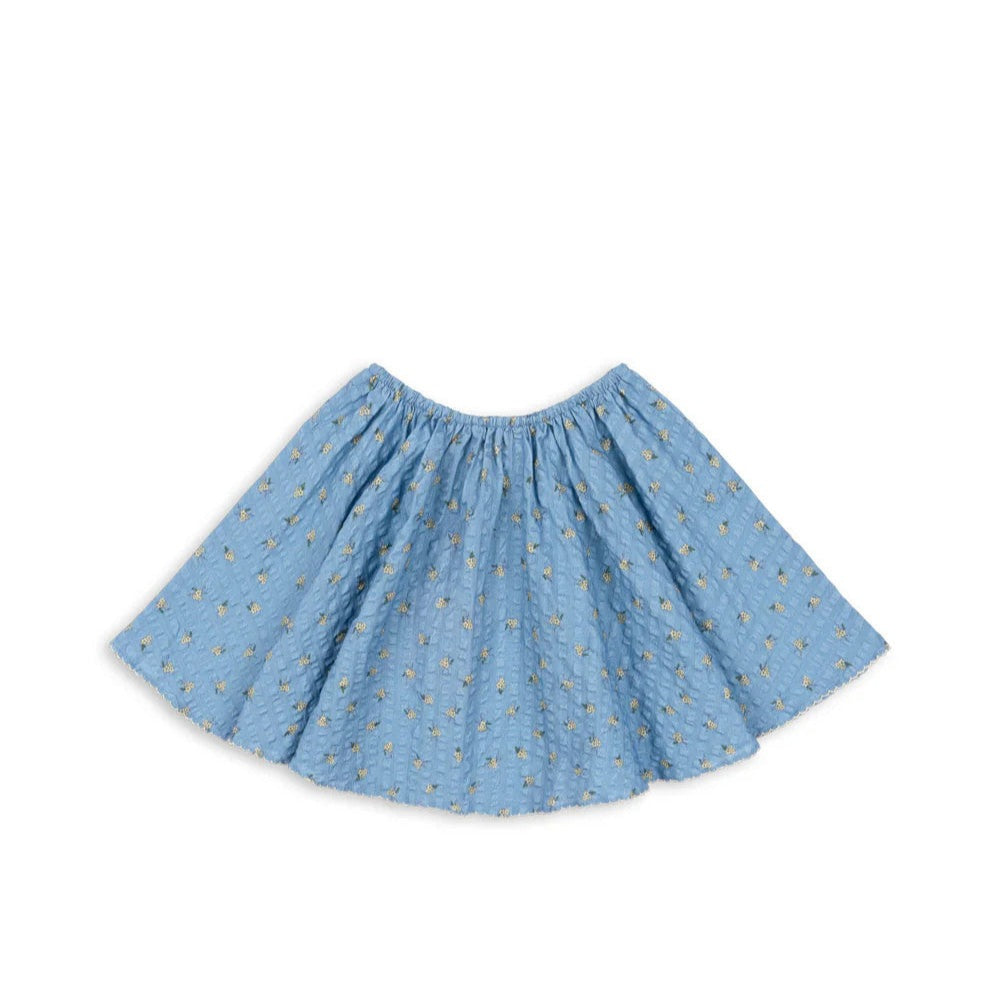 Konges Slojd Kim Skirt Billie Blue baby skirt with gathered waist, shown spread to reveal fluttery silhouette and tiny yellow florals