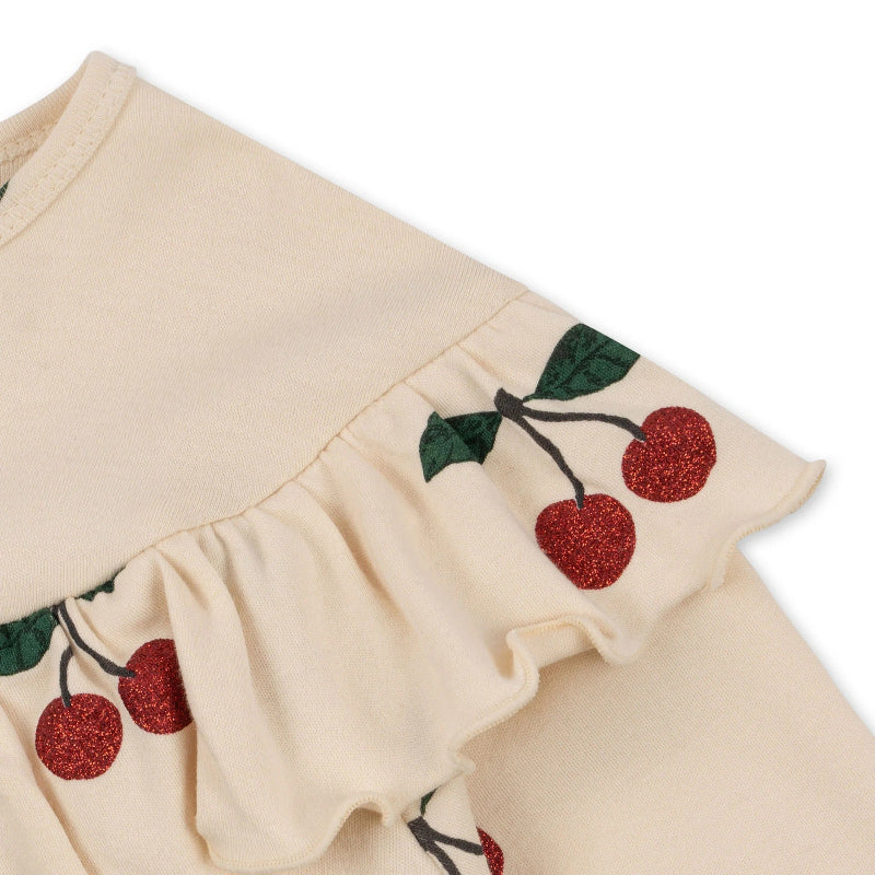 Konges Slojd Malli Glitter Blouse in cream knit with a glittery cherry-embellished ruffle across the chest.