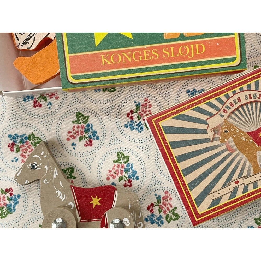 Konges Slojd Matchbox Animals wooden horse figure with red saddle detailing beside vintage matchbox art.