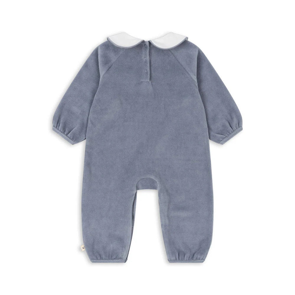 Konges Slojd Miffa Onesie Trade Winds blue velour with white collar and footed design, shown laid flat.