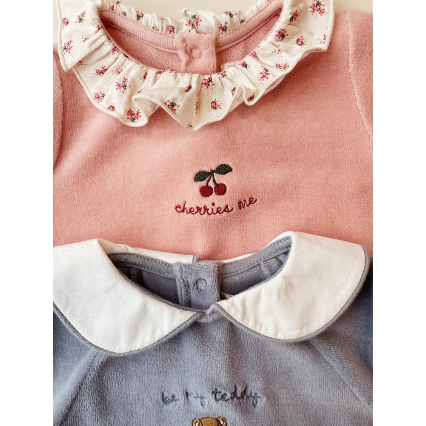 Konges Slojd Miffa Onesie set: pink with ruffled floral collar and cherry embroidery, blue with white Peter Pan collar.
